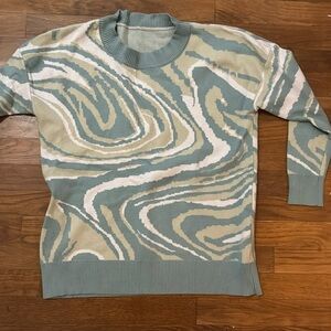 Green and blue swirl patterned sweater.
